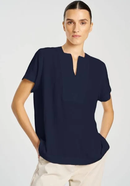 Person wearing a navy blue top with a plain background