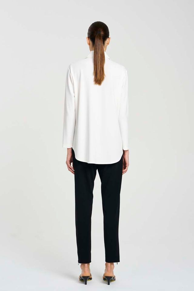 Person wearing a white blouse and black pants on a white background