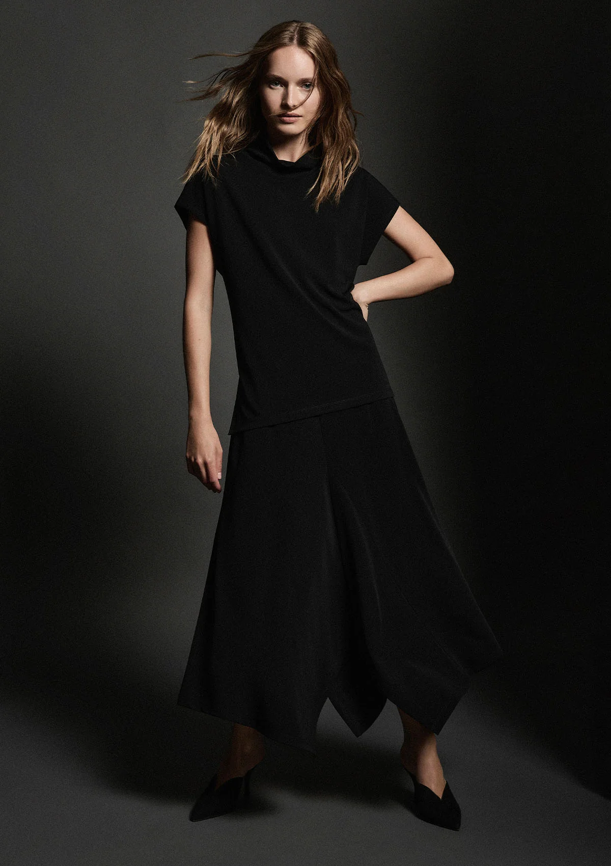 Woman wearing a black dress against a dark background