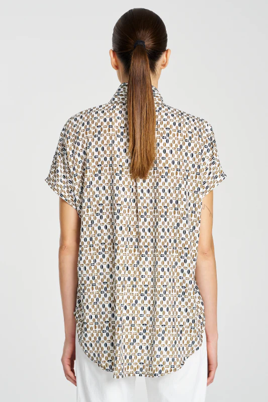 Woman wearing a patterned shirt with a plain background