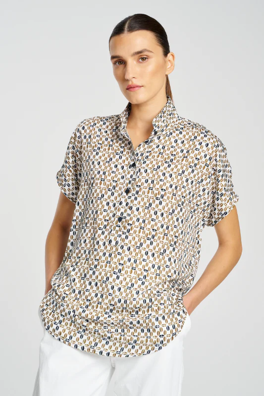 Woman wearing a patterned shirt with a plain background