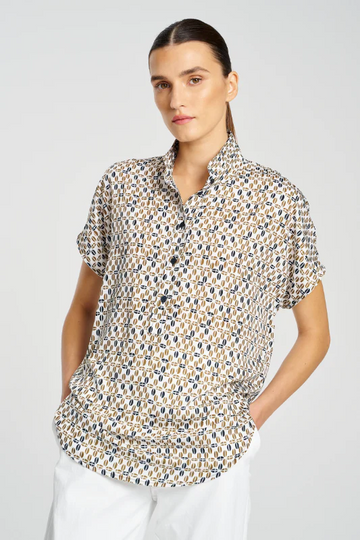 Woman wearing a patterned shirt with a plain background