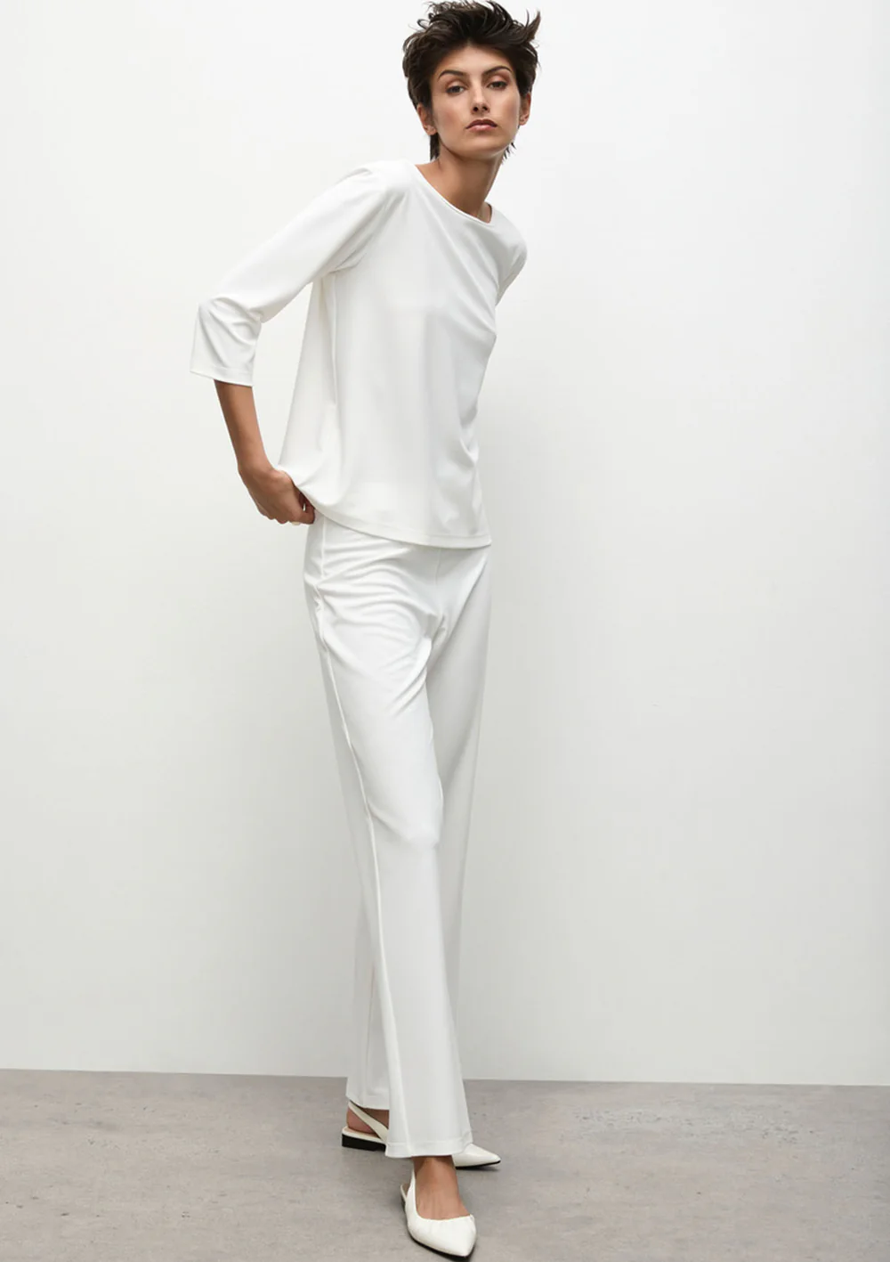 Person wearing a white outfit against a plain background