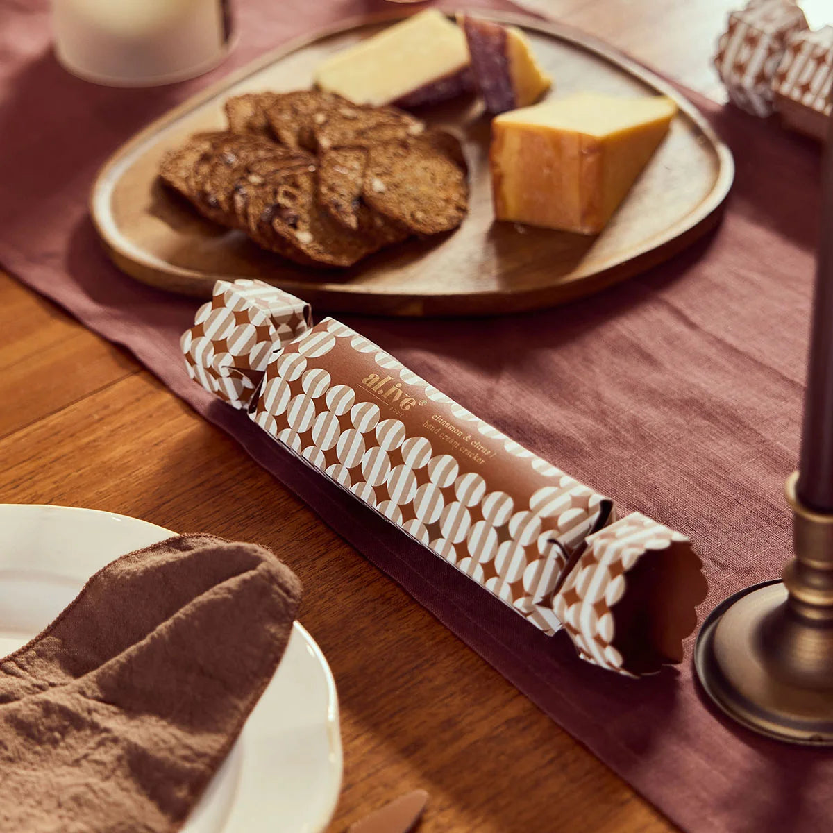 al.ive body Hand Cream Cracker on a festive table setting with cheese and crackers