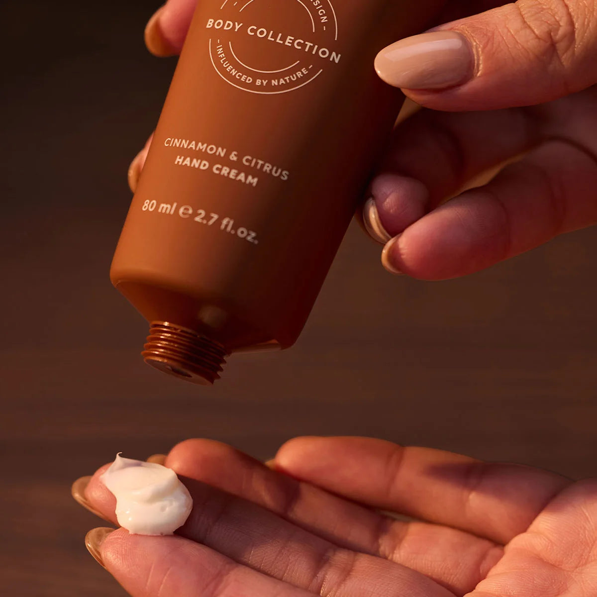 al.ive body Cinnamon & Citrus Hand Cream being squeezed onto a hand