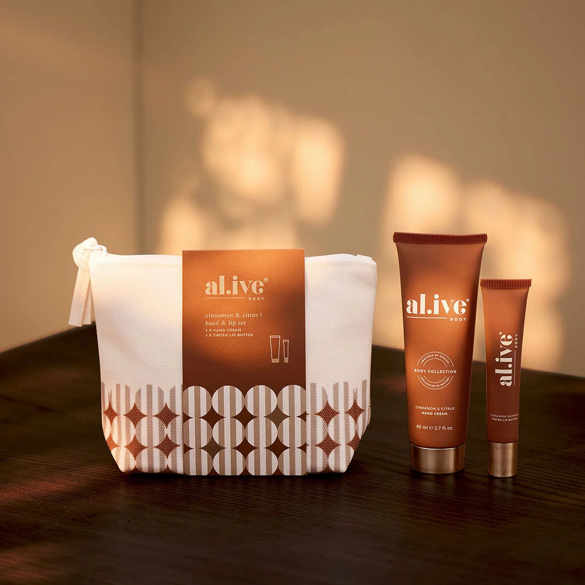 al.ive body Hand & Lip Set cosmetic bag with hand cream and lip butter on a timber table
