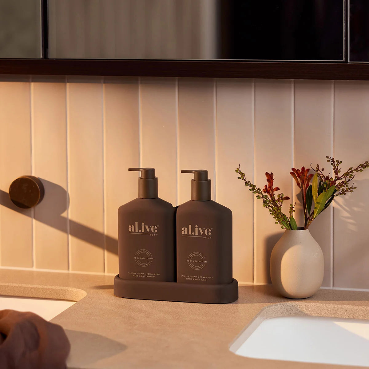 al.ive body Transformative Wash & Lotion Duo styled beside a bathroom basin with native flowers