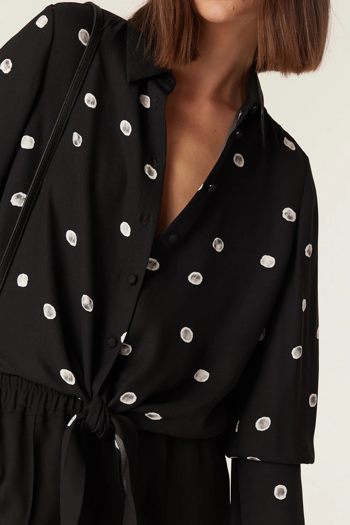 Close-up of the collar, button placket and hem tie detail on the Cable Melbourne Hepburn Blouse in Black Spot