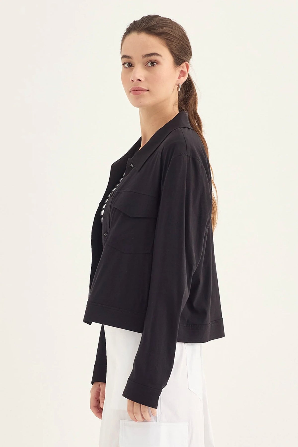 Verge Acrobat Icon Jacket in Black, worn - side with a white skirt